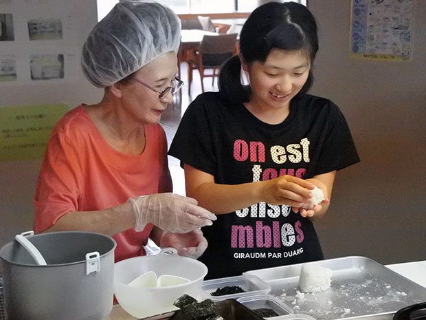 L'idole locale d'Aomori, "Ringo Musume", fabrique des boulettes de riz, et la troisième génération d'Okami, un restaurant japonais établi de longue date, enseigne