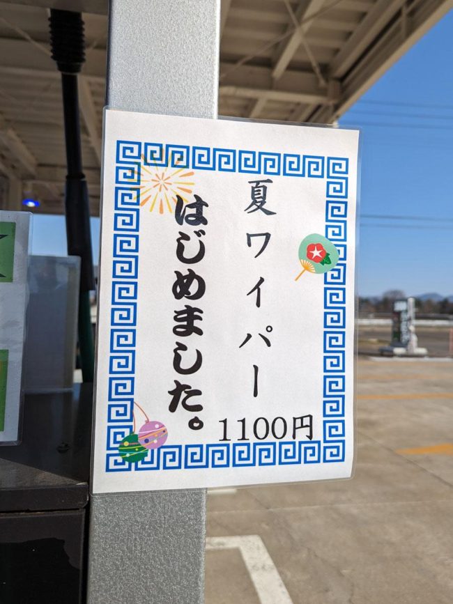 Cartel de "limpiaparabrisas de verano iniciado" en una gasolinera en Hirosaki