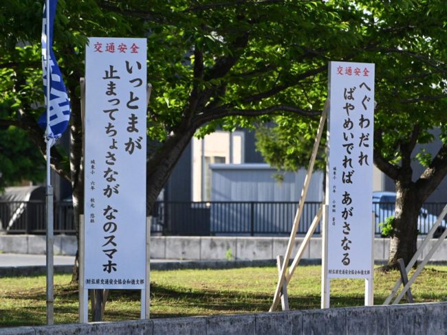 Tsugaru बोली में यातायात सुरक्षा नारों के लिए प्राथमिक विद्यालय के छात्रों द्वारा "बायैदे" और "मैहंडे" चार नए कार्य